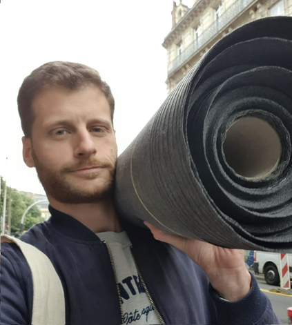 Jérôme avec un rouleau de tissu à Paris